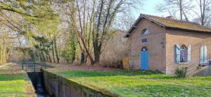 Vue du canal de la Sauldre avec une petite maison éclusière en brique